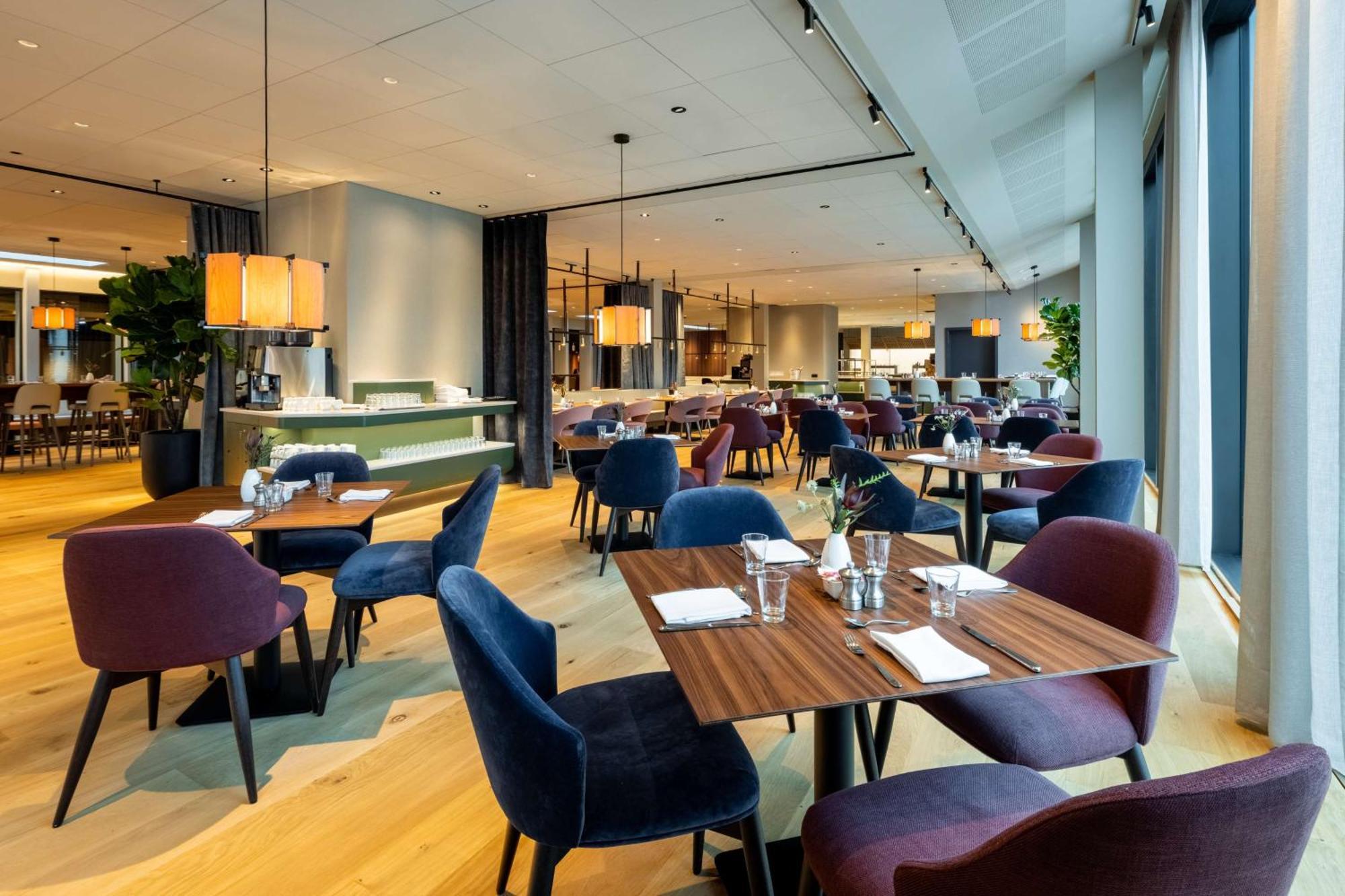 Hotel Nh Collection Copenhague Exterior foto The photo showcases a modern restaurant interior with a spacious and elegant design. It features wooden flooring and a combination of light and dark furnishings. There are several tables set for dining, each with utensils and glasses. The chairs come